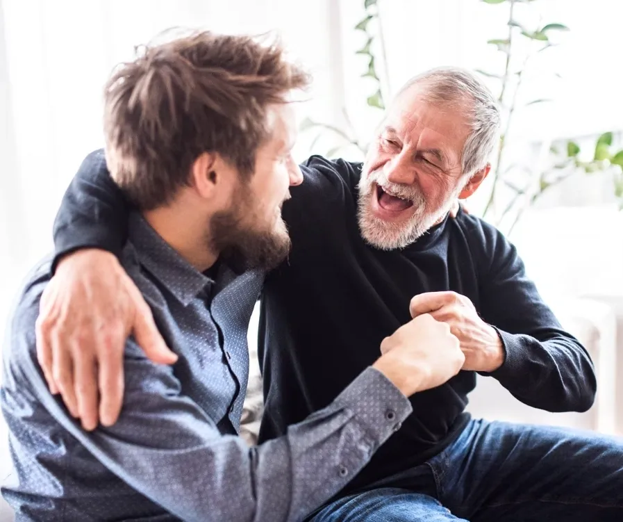 Older and younger man smiling together